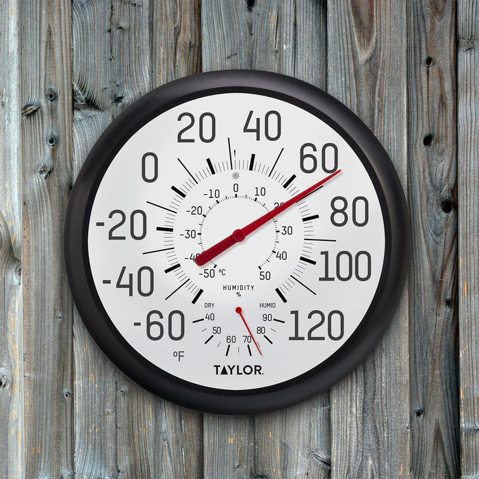13.25 inch black and white thermometer and hygrometer mounted on a weathered wooden fence with a red needle.