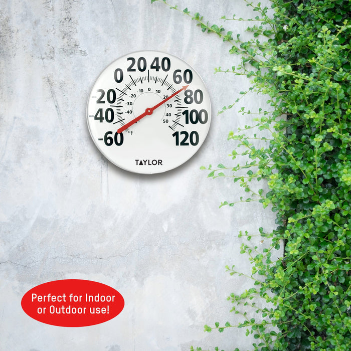 18 inch metal patio thermometer by Taylor on a concrete surface with greenery in the background