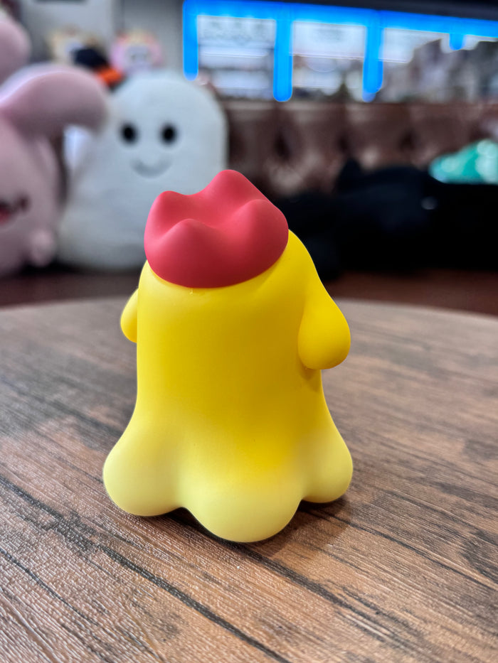MYONNY - yellow by PYOS, a 9cm stylized toy with a scalloped base and red cap, sits on a wooden table.
