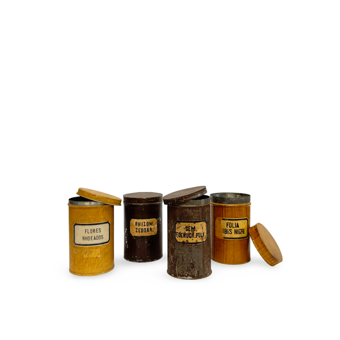 Set of four antique pharmacy canisters with round lids and vintage printed labels