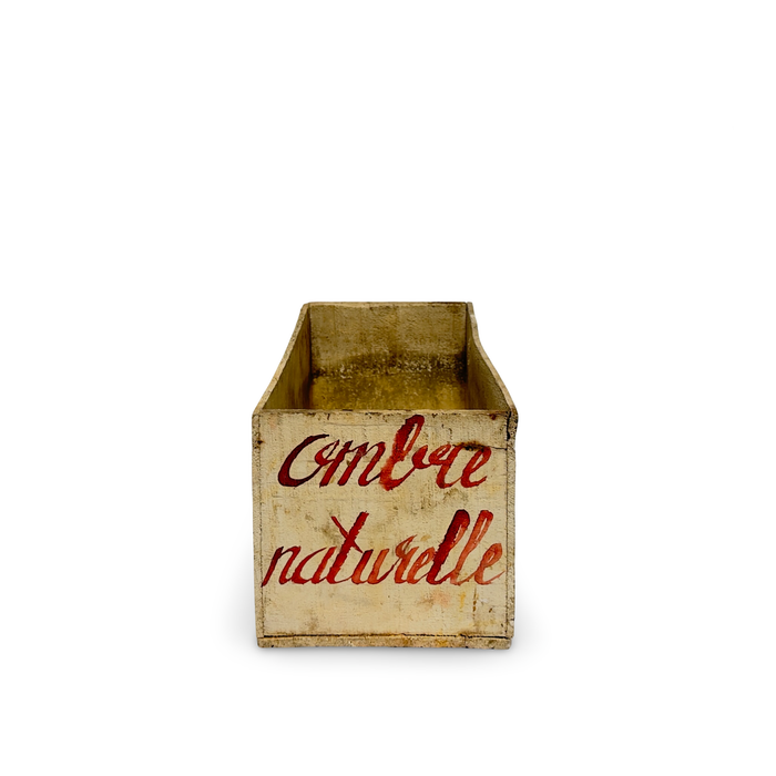 Antique French pigment storage container with brown interior and red “Ambre naturelle” label