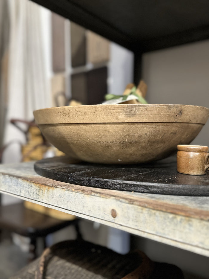 Antique wooden bowl on tabletop, natural worn finish with wide rim