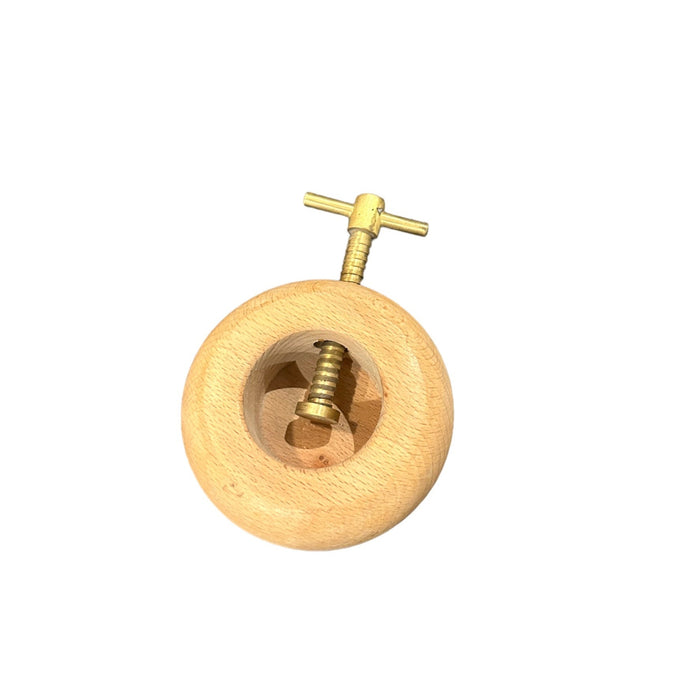 Wooden round nutcracker with brass screw and handle, close-up
