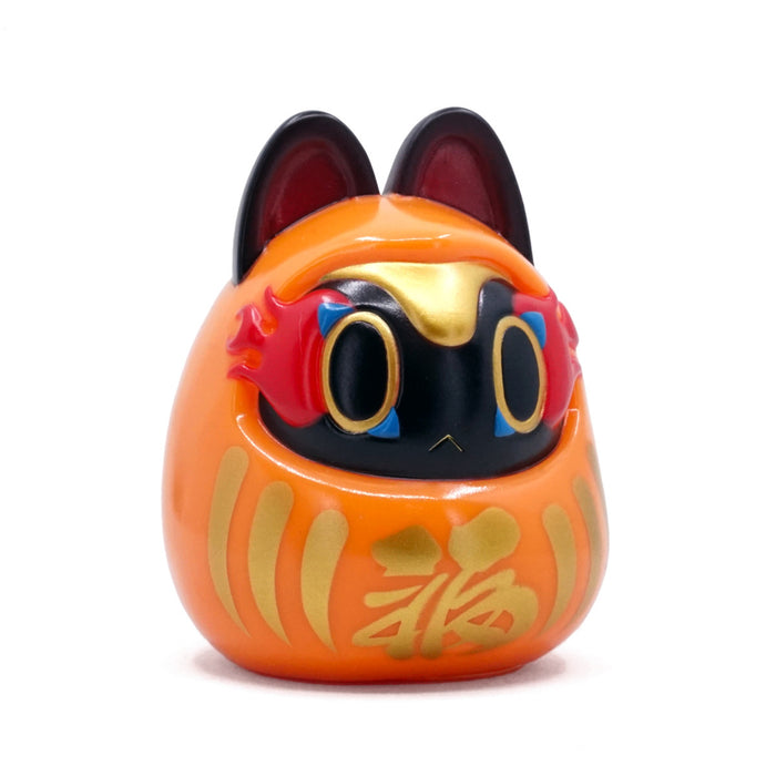 Folktoy Kaiju INUHARI-DARUMA “Orange” by Teresa Chiba, a 10cm egg-shaped figure blending a daruma doll with a cat, featuring gold kanji and flame-like details.