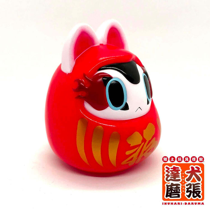 Folktoy Kaiju INUHARI-DARUMA “Red” by Teresa Chiba, a 10cm red sofubi figurine with big eyes and pointy ears, resembling a whimsical animal daruma.
