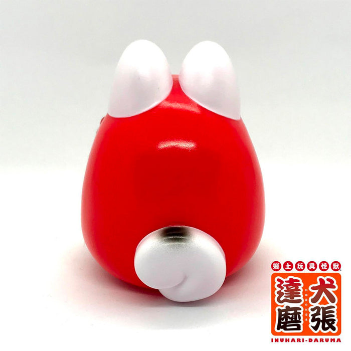 Folktoy Kaiju INUHARI-DARUMA “Red” by Teresa Chiba: A 10cm sofubi toy depicting a dog-shaped Daruma with a rounded red body, white ears, and tail.