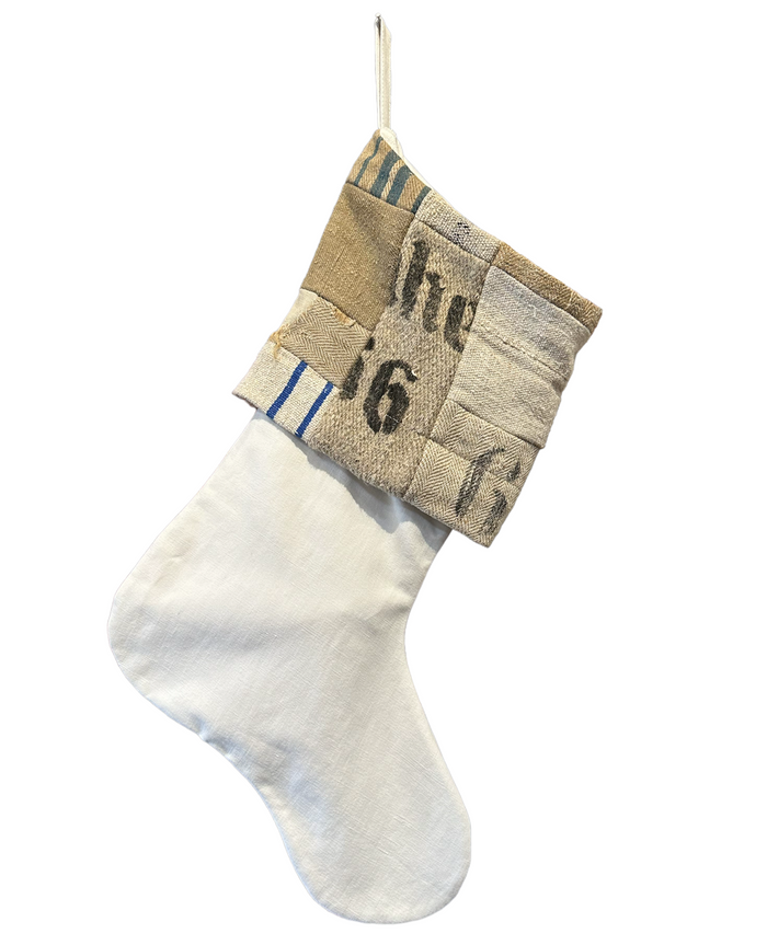 Christmas stocking with beige patchwork cuff and white knit body, blue and black numbers