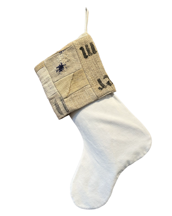 Christmas stocking with beige patchwork cuff and white knit body, dark motifs and numbers