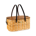Handwoven wicker picnic basket with dark leather handles and wooden lid