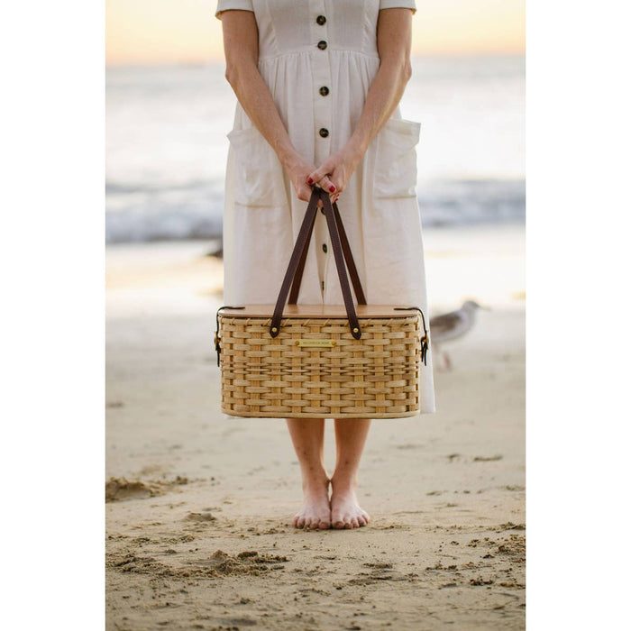 Handwoven wicker picnic basket with dark leather handles and wooden lid