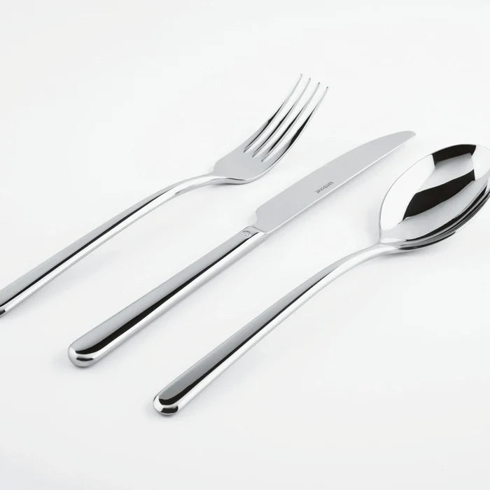 The Sambonet Linear Solid Handle Flatware 5 Place Setting—featuring sleek modern design—is artfully displayed side by side on a white surface.