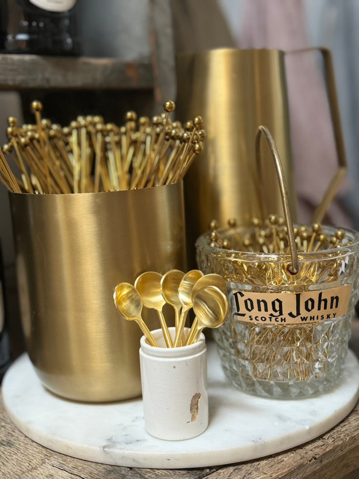 Mini antique French crock holding gold cocktail picks; cream ceramic with small blemish