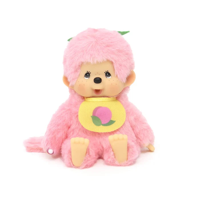 Monchhichi Fruit Beanies Plush: A 5.5 pink plush monkey with big eyes, wearing a yellow bib with a peach graphic and green leaf accents.