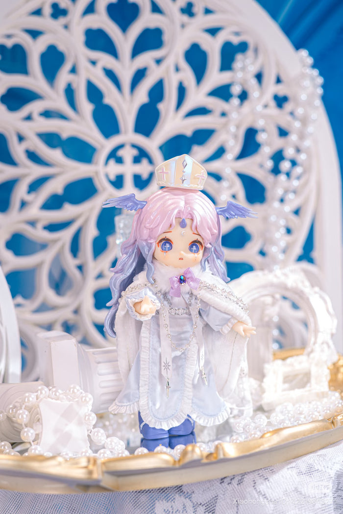NAGI: The Phantom Record Series Articulated Figure in angelic-bishop attire with pastel hair, delicate accessories, and ornate robe on decorative tray, available for preorder.