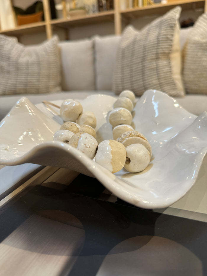 Off-white ceramic catchall bowl with glossy finish, scalloped rim, shallow dish